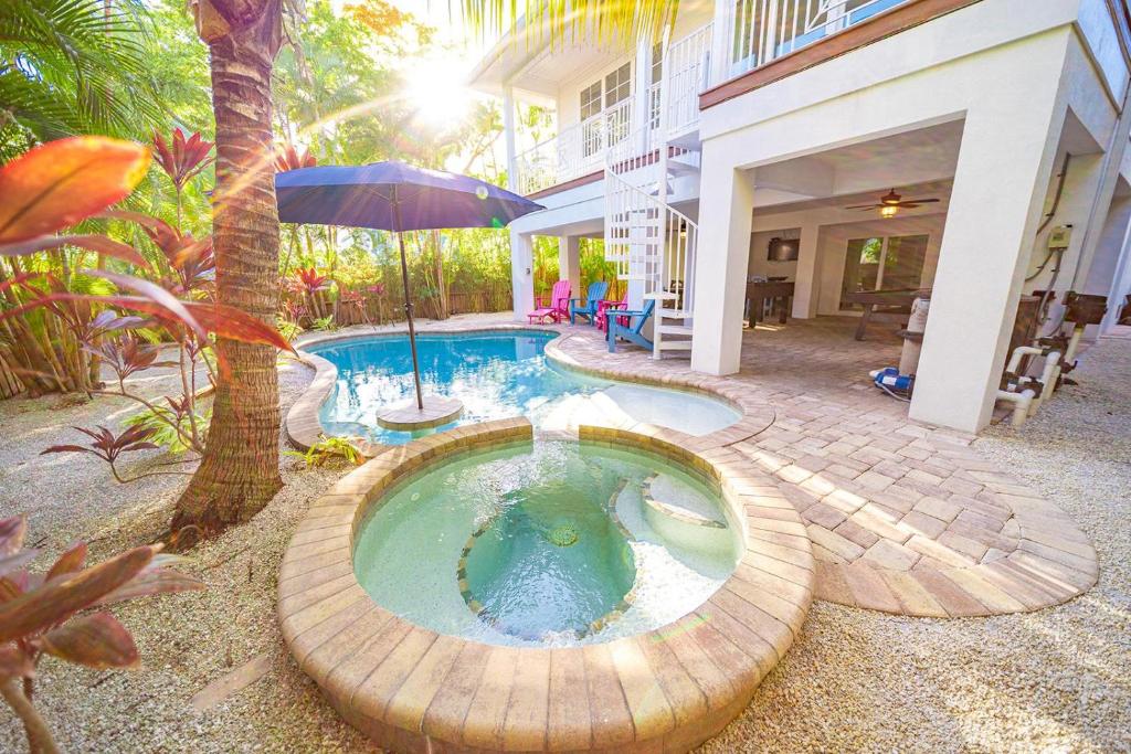 安娜玛丽亚Antigua Bay的一座房子旁带遮阳伞的游泳池