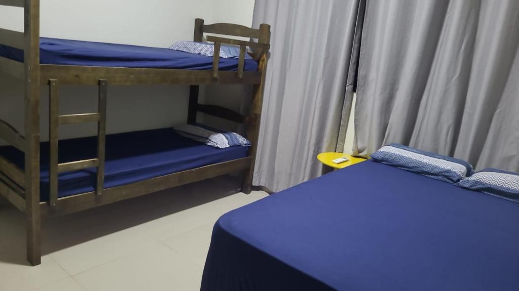 奥林匹亚Recanto da Tairine的客房设有两张双层床和一张蓝色的床。