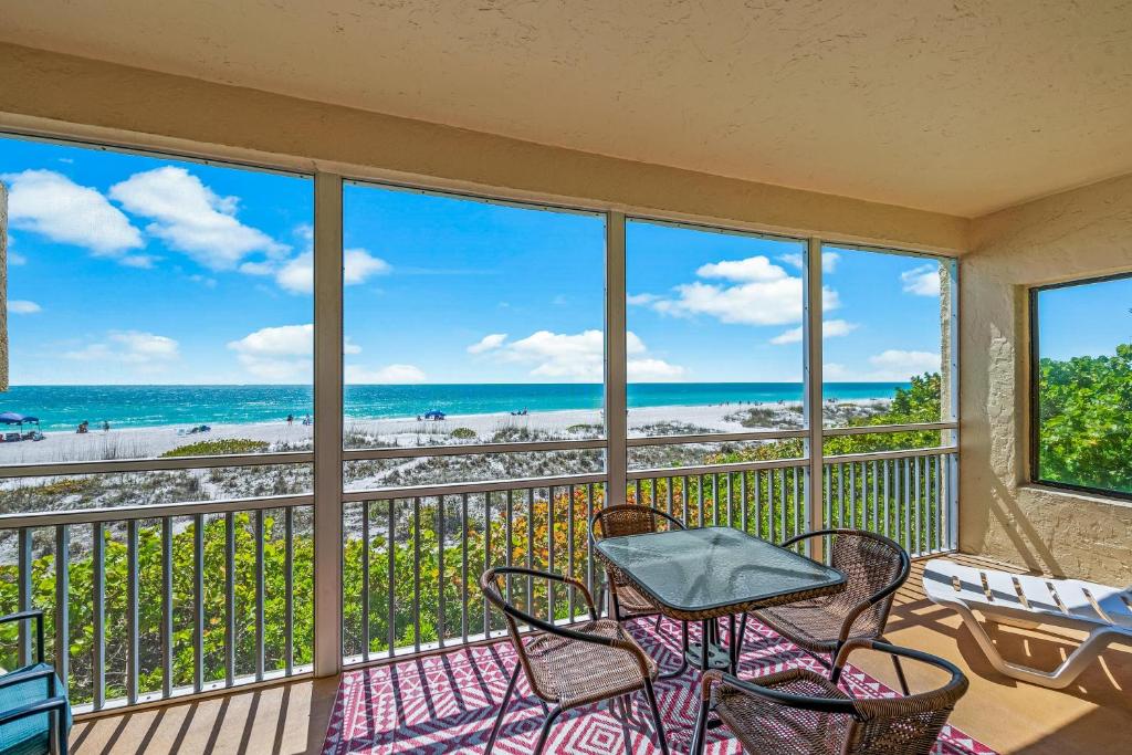 霍姆斯海滩Gulf Shores 106的阳台配有桌椅,享有海滩美景。