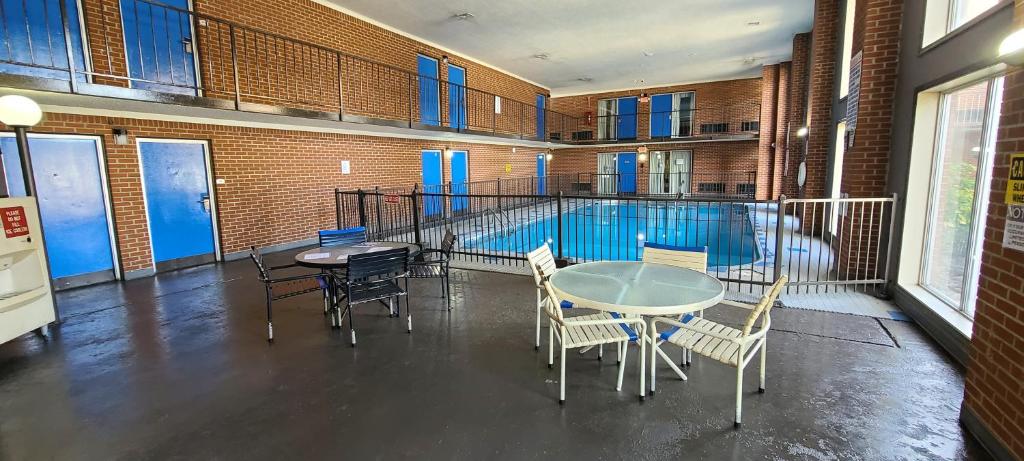 琼斯伯勒Fairview Inn & Suite的配有桌椅的房间和游泳池