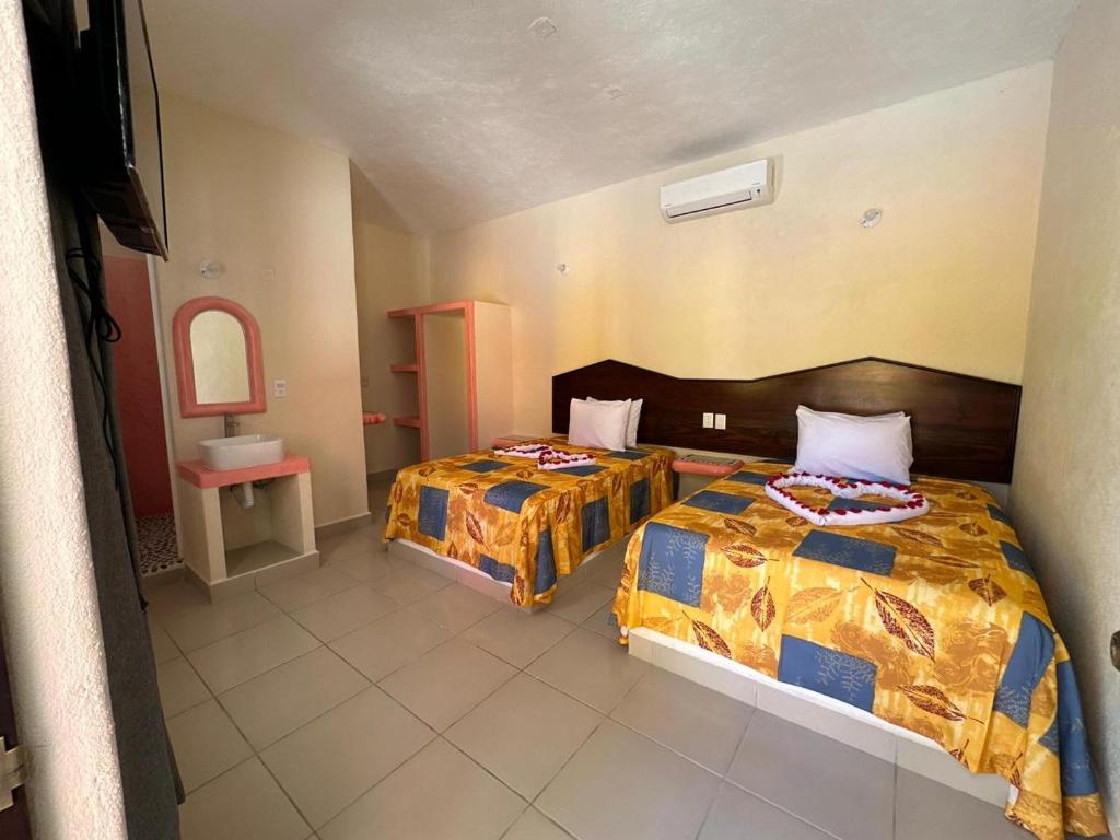 锡瓦塔塔内霍Hotel Posada Purépechas的一间卧室配有两张床和水槽