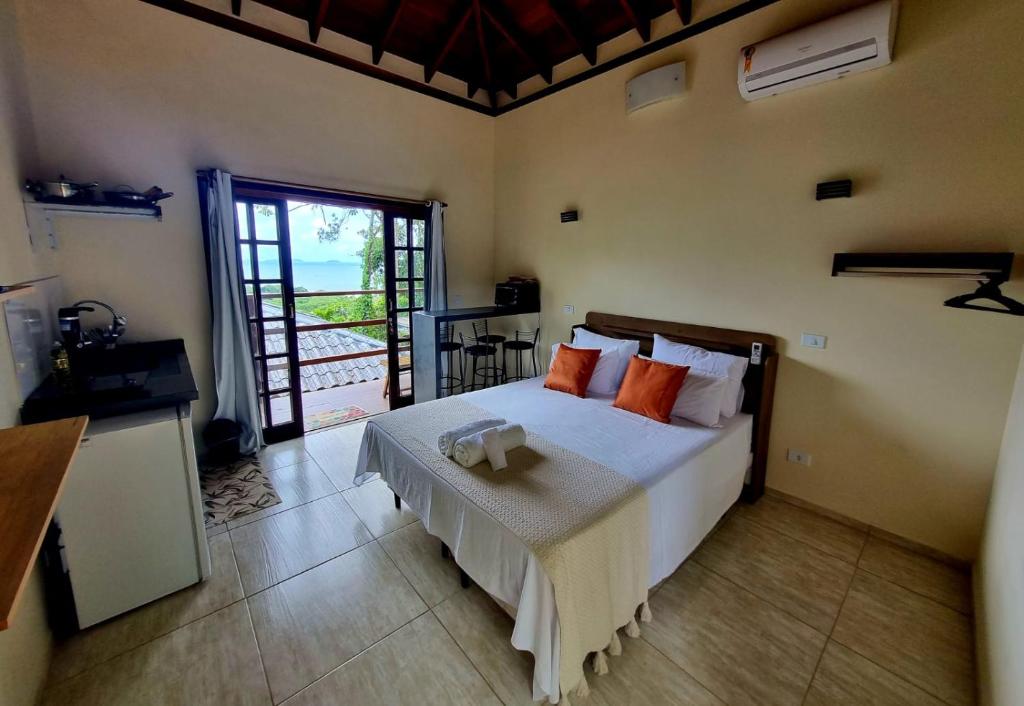 乌巴图巴Burung Flats Itamambuca - Hospedagem com vista para o mar的一间卧室配有一张带橙色枕头的大床