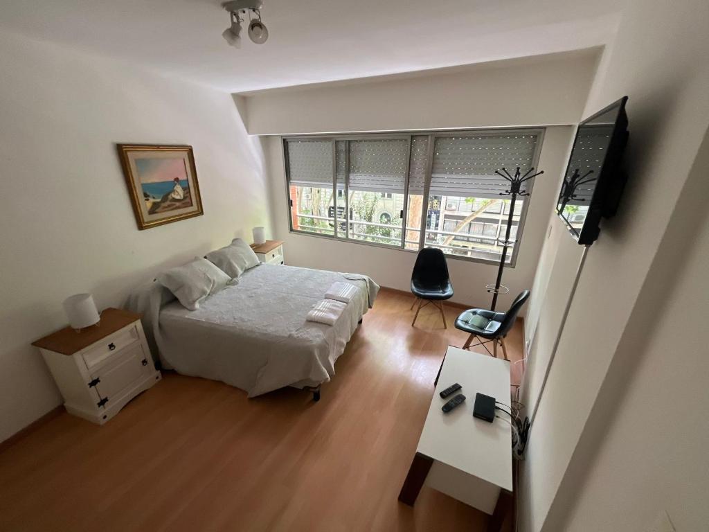 蒙得维的亚Apartamento en Pocitos的一间卧室配有一张床和一台平面电视
