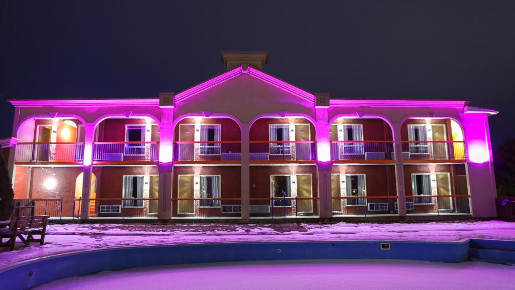 若列特Motel Classique的一座大型建筑,上面有粉红色的灯光