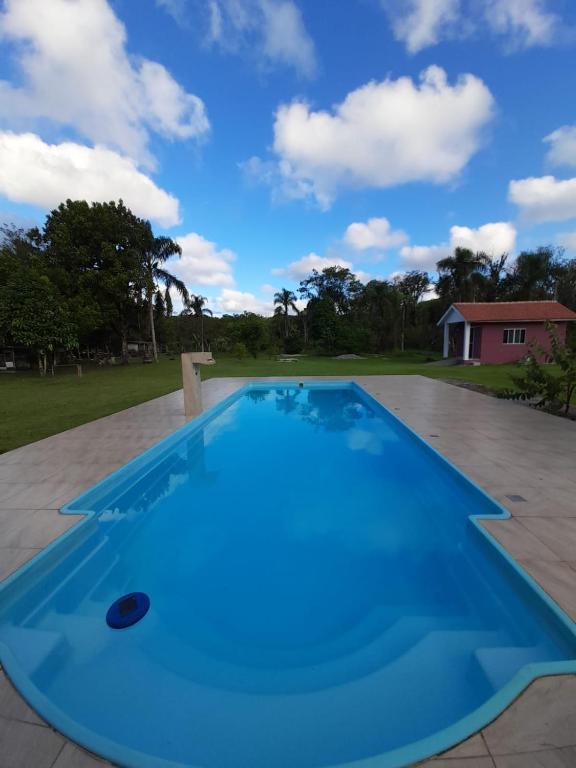 巴拉那州蓬塔尔Mini Casa Chácara Zulin's - AMOR E ACONCHEGO的庭院里的一个大型蓝色游泳池