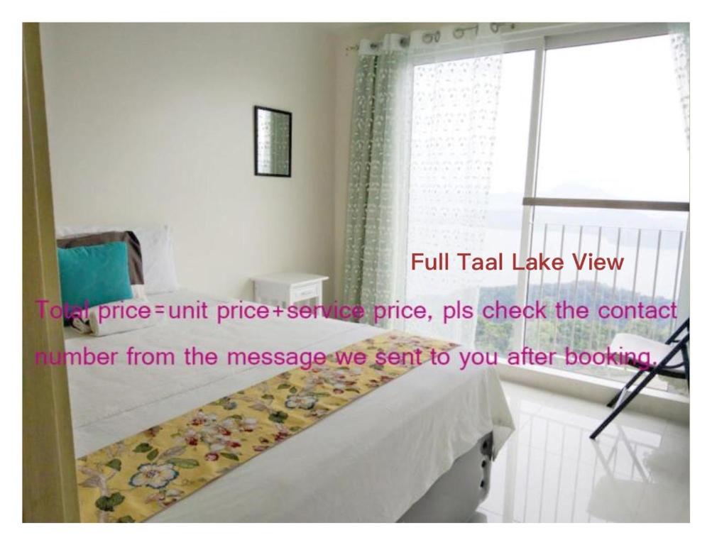 大雅台SMDC Franchesca's Taal Lake View Condo No Balcony - Studio & Partial Lake View Condo No Balcony - Standard Quadrouple Room Netflix的客房设有床、窗户和防滑装置。