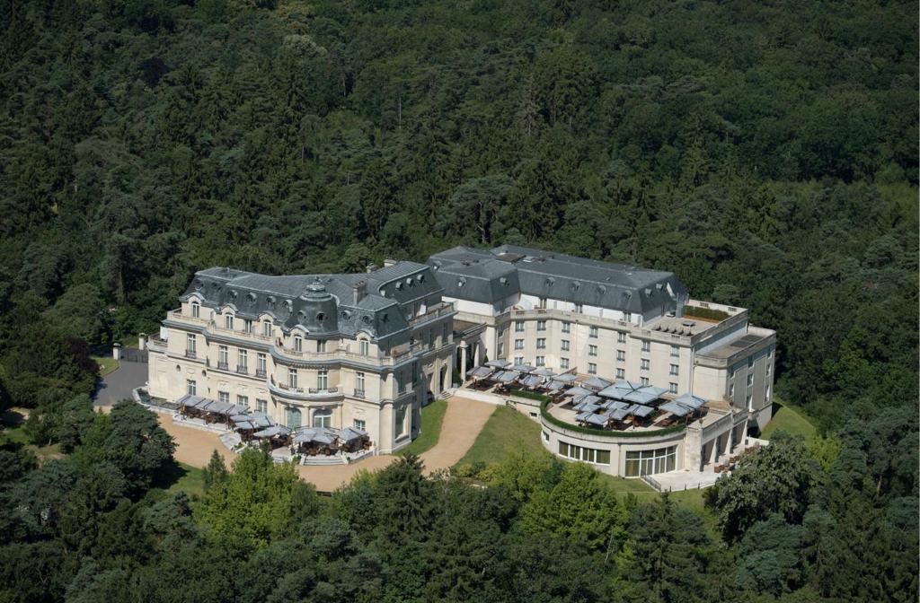 拉沙佩勒InterContinental Hotels Chantilly Chateau Mont Royal, an IHG Hotel的森林中大房子的空中景观
