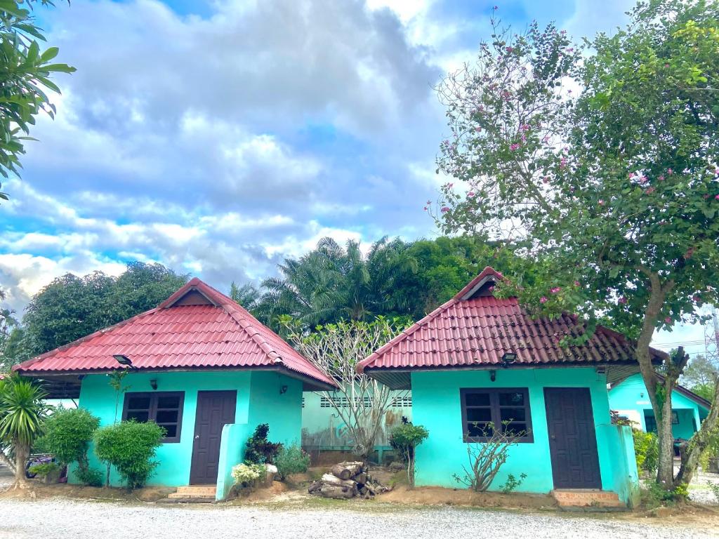 Ban Samnak PlingThungtako Resort的一间蓝色的小房子,有红色的屋顶