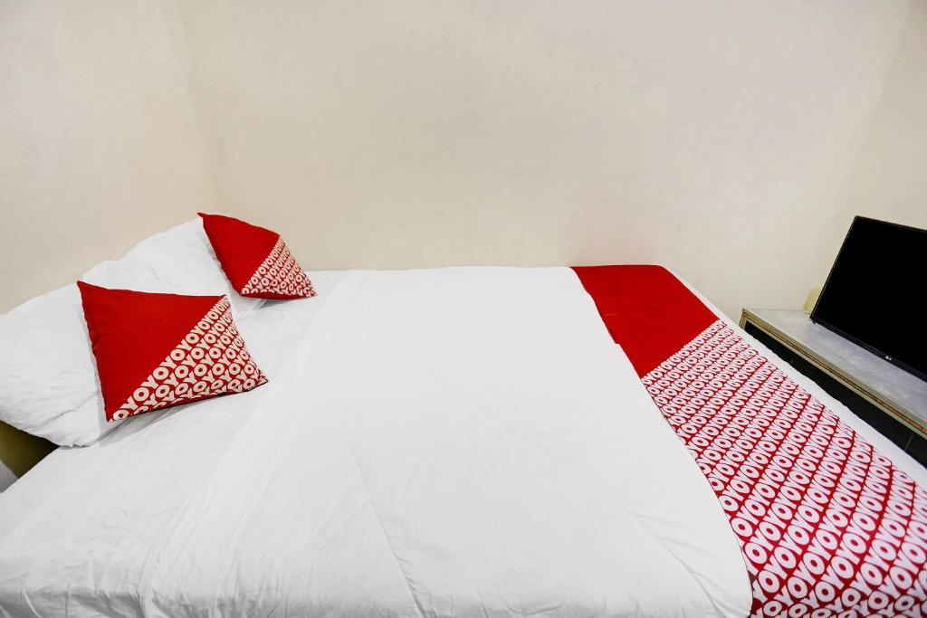 JodohSPOT ON 91422 Ringin Pitu 2 Syariah的白色的床和红色和白色的枕头