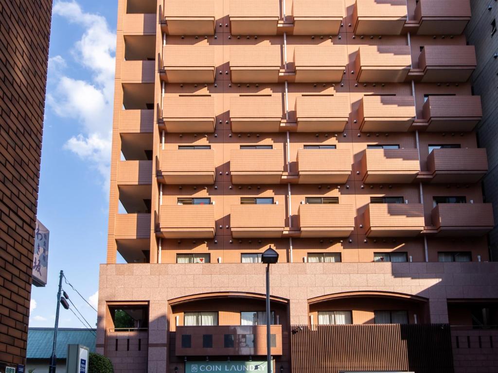 东京门前仲町东急酒店的一座高大的建筑,旁边设有阳台