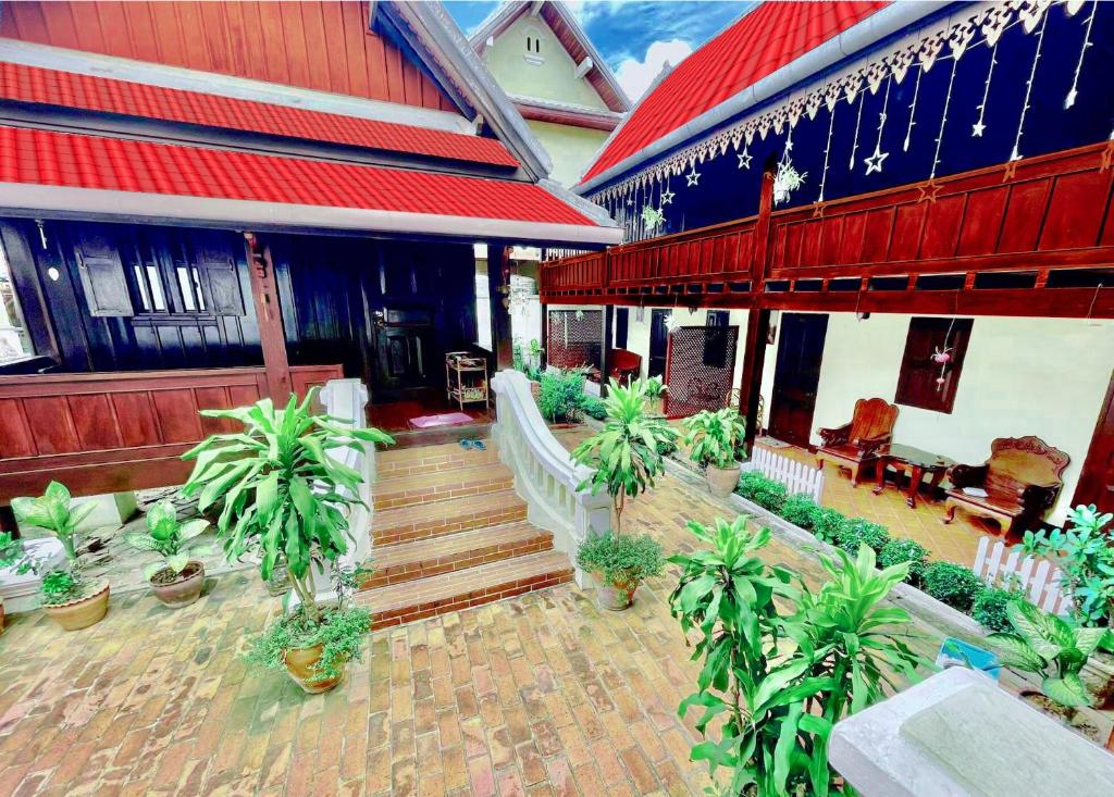 琅勃拉邦Villa Phathana Royal View Hotel的楼前有盆栽植物的房子