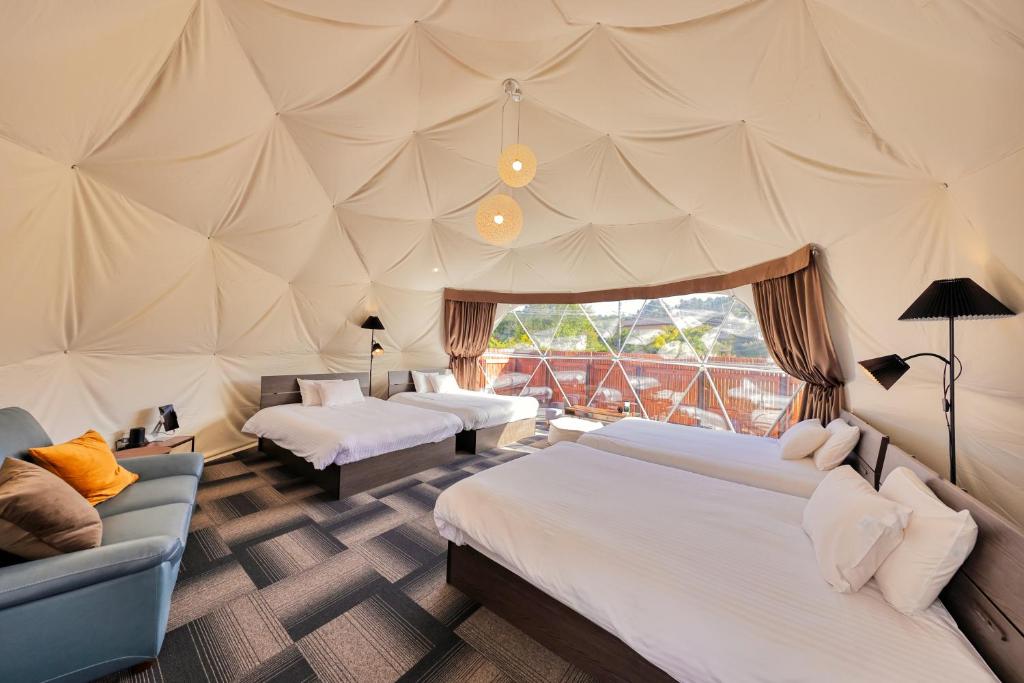 富士河口湖スイートグランピング河口湖的帐篷卧室配有两张床和一张沙发