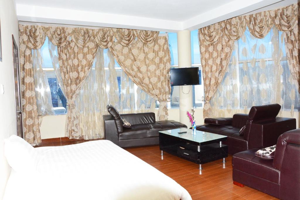 阿克苏姆Yaredzema International Hotel的一间卧室配有一张床、一张沙发和椅子