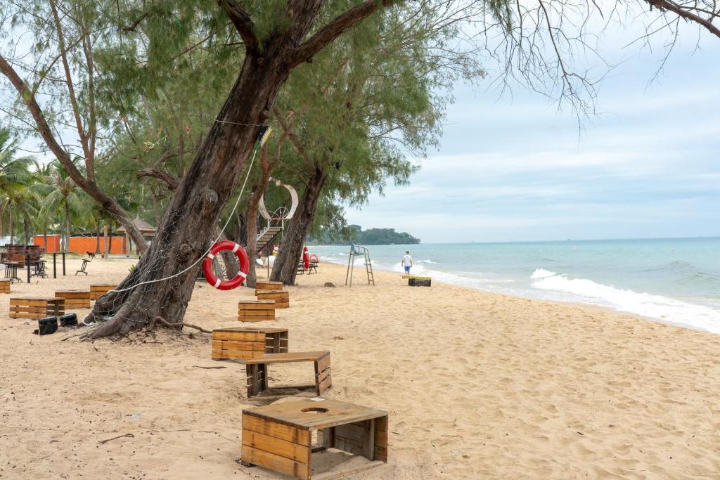 富国Tropical Bay Grand World Phu Quoc的长椅和树的海滩和海洋