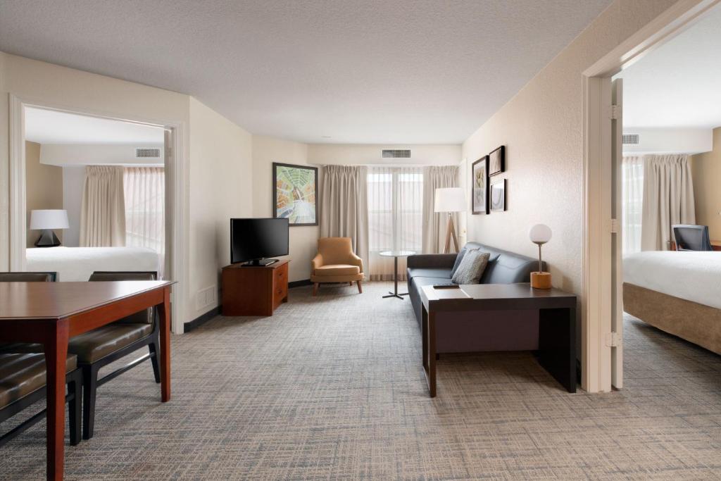 罗杰斯罗吉斯万豪原住客栈的酒店客房配有一张床、一张沙发和一张书桌。