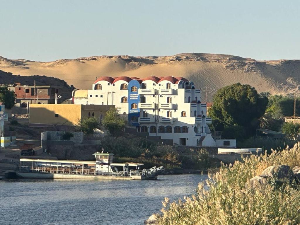 Naj‘ al MaḩaţţahACHERTOD NUBIAN HOTEL的河边的白色大建筑