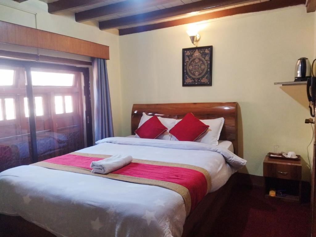巴克塔普尔HOTEL RUPAKOT AND ROOFTOP RESTAURANT的一间卧室配有一张带红色枕头的大床