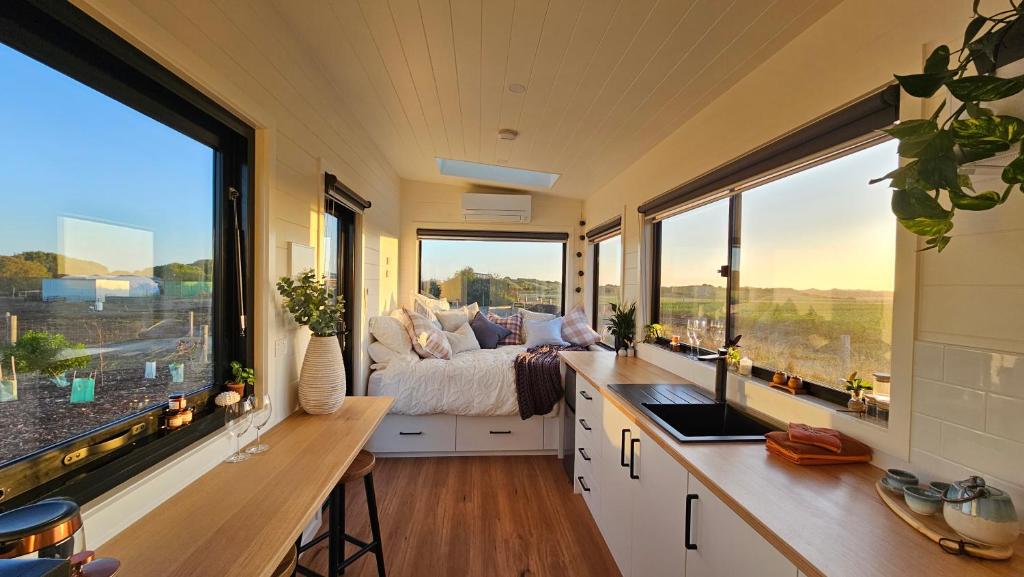 KillarneyCoastal Sunset Tiny Home - Port Fairy Tiny Homes的一间卧室设有一张床和大窗户