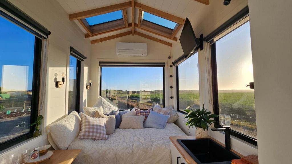 KillarneyCoastal Haven Tiny Home - Port Fairy Tiny Homes的客厅的窗户前设有沙发