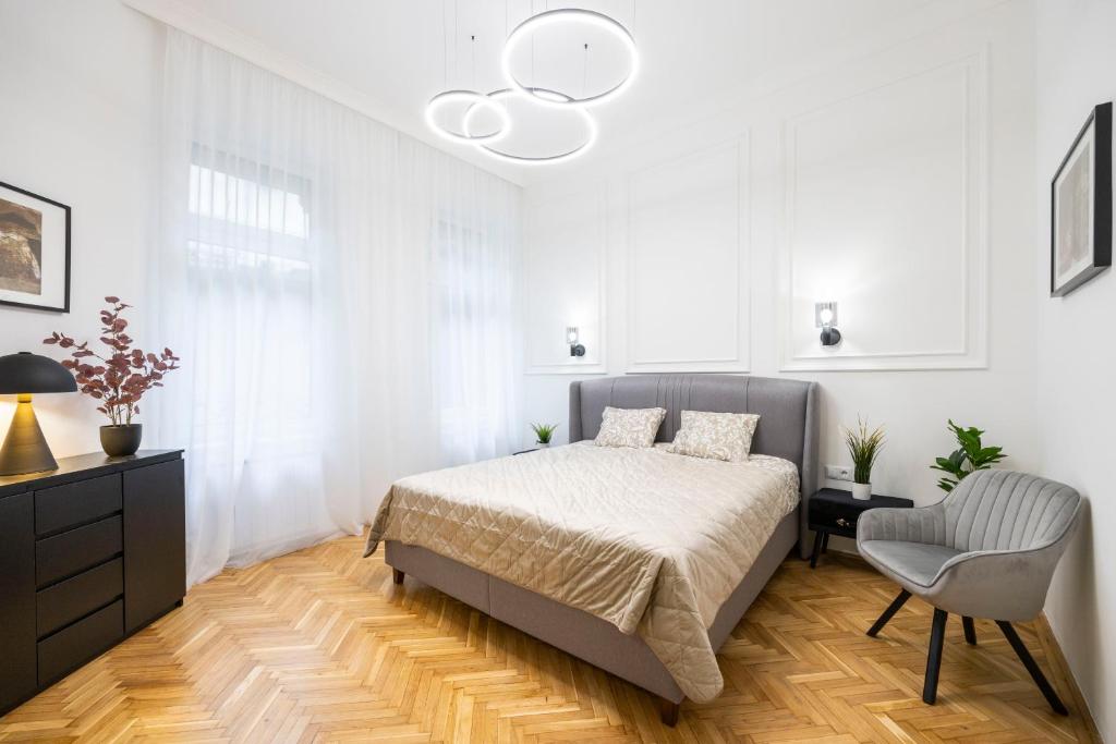 布达佩斯Luxurious Central 4BEDRM 3BATHRM Residence w/ Balcony的白色卧室配有床和椅子