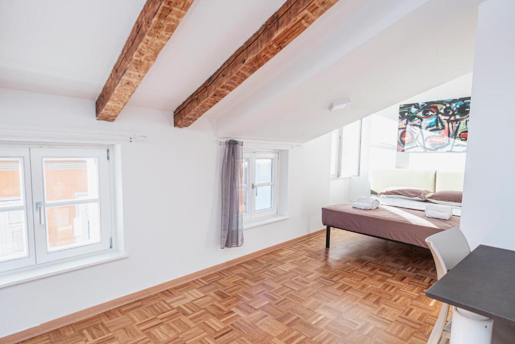 的里雅斯特Le Finestre Boutique Apartments的白色的客房设有一张床和两个窗户。