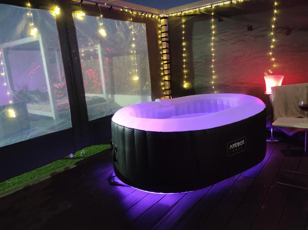 隆达Ático Rilque的一个带灯光的客房内的按摩浴缸