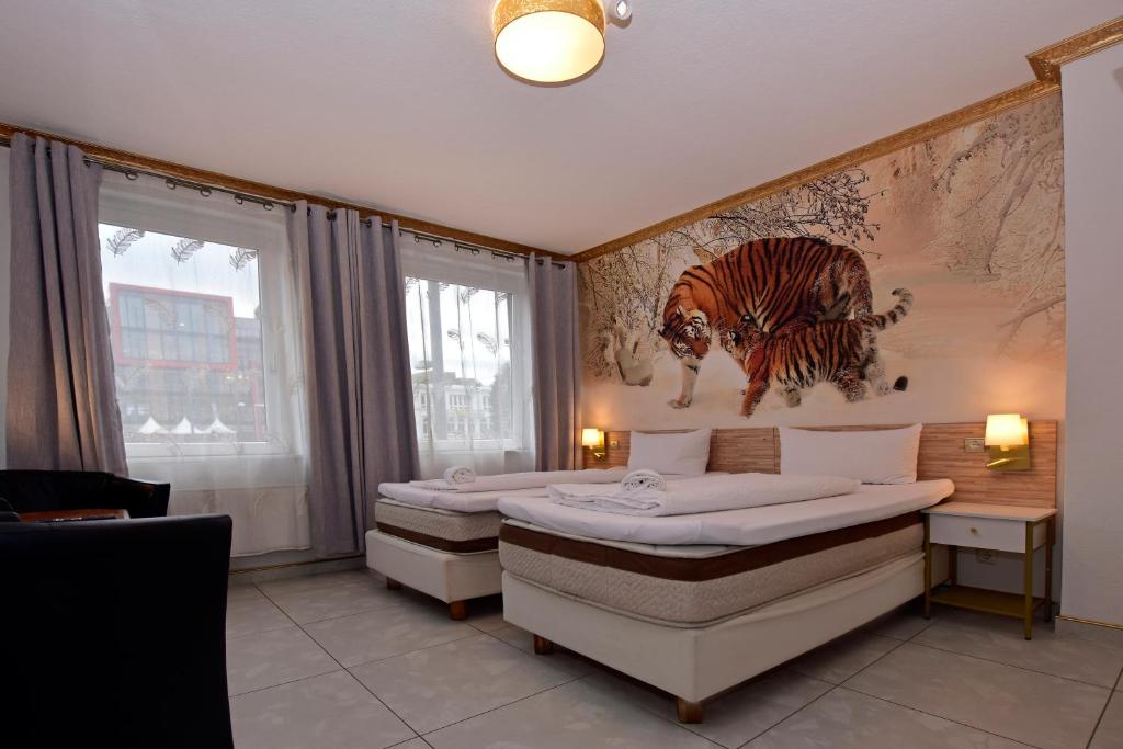 汉堡阿姆本特奈科斯特旅馆的一间卧室配有两张床,画着一幅老虎画
