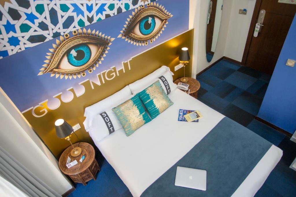 格拉纳达Casual Ilbira Granada的一间卧室配有一张带镜子的床,铺有蓝色的地板