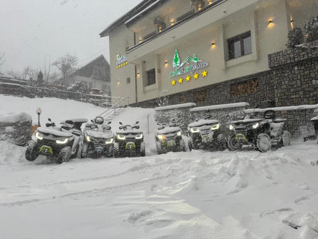 锡纳亚Chalet jolie Luxury Vila Sinaia的停在大楼前的一排雪覆盖的摩托车
