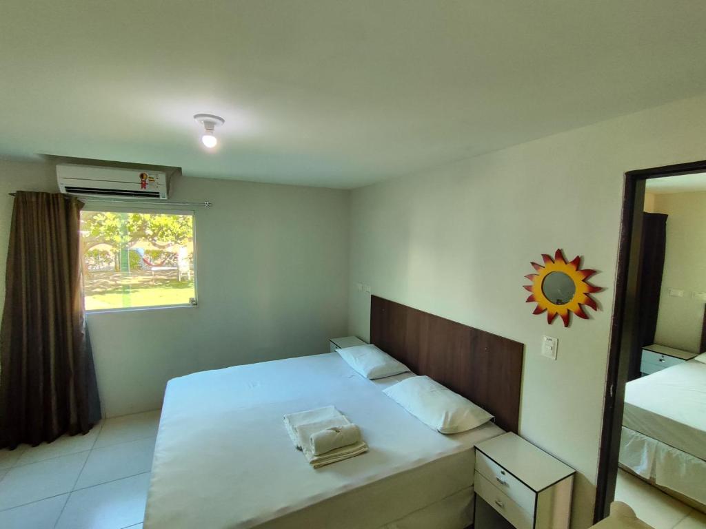 普拉亚多斯卡内罗斯Divinos Flat Carneiros的一间卧室配有一张床、镜子和窗户