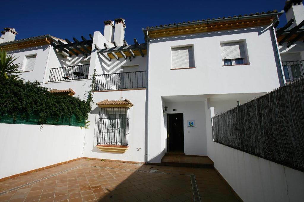 埃尔博斯克Casa Rural Rafael Alberti的白色的房子,设有大门和庭院