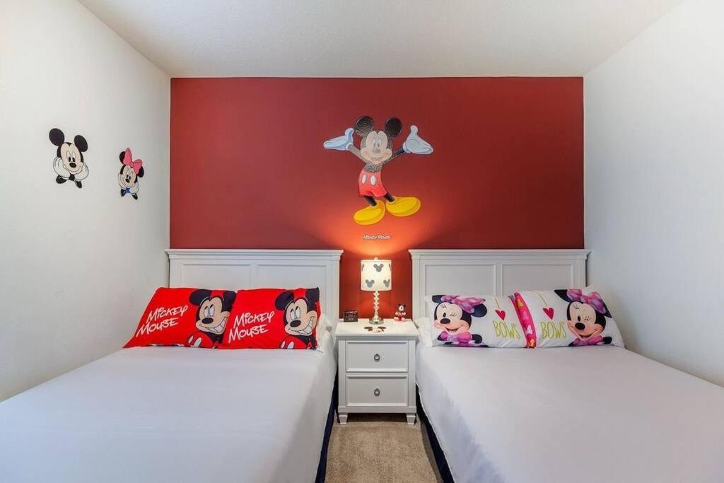 基西米Enjoy a Cozy 3 BR/Clubhouse/Near Disney and more的一间卧室设有两张床,墙上装饰有微米老鼠