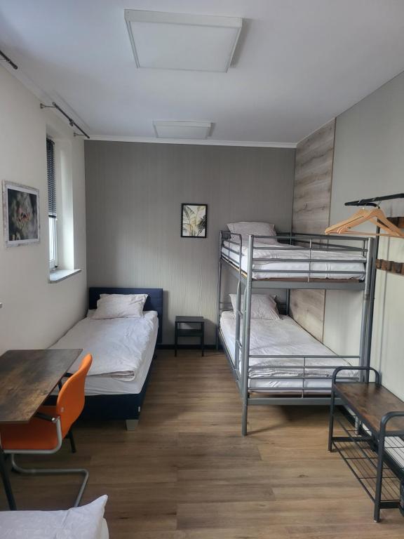 华沙Rooms4Rest Bokserska - Private rooms for tourists - ATR Consulting Sp, z o,o,的客房设有两张双层床和一张桌子。