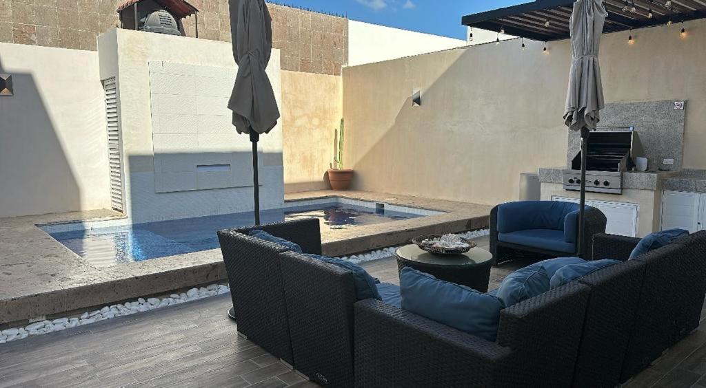 拉巴斯Casa Completa con Alberca privada的一个带两把椅子和遮阳伞的游泳池