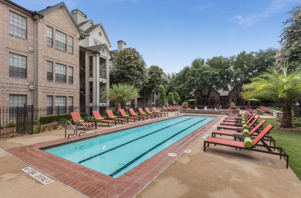 休斯顿Amazing Houston Apartment with Pool+ Fast Internet的一座带躺椅的游泳池和一座建筑