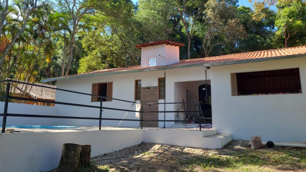 雅里努Chácara com piscina em Jarinu的白色房子,有红色屋顶