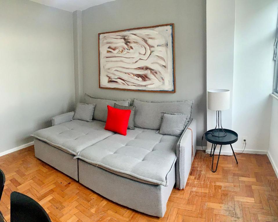 里约热内卢Fronteira Leblon/Ipanema - Vista fantástica!的一张沙发上红色枕头,放在一个房间里