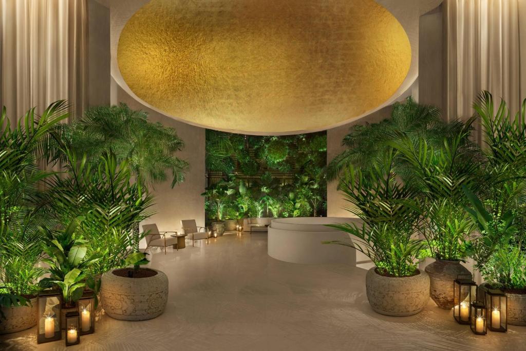 新加坡The Singapore EDITION的大堂拥有盆栽植物和大型金色天花板