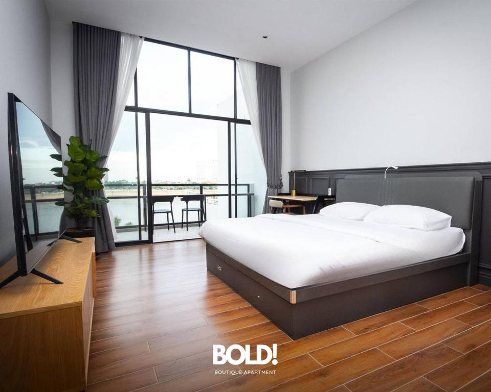 金边BOLD! apartment @ Riverside的一间卧室设有一张床和一个大窗户