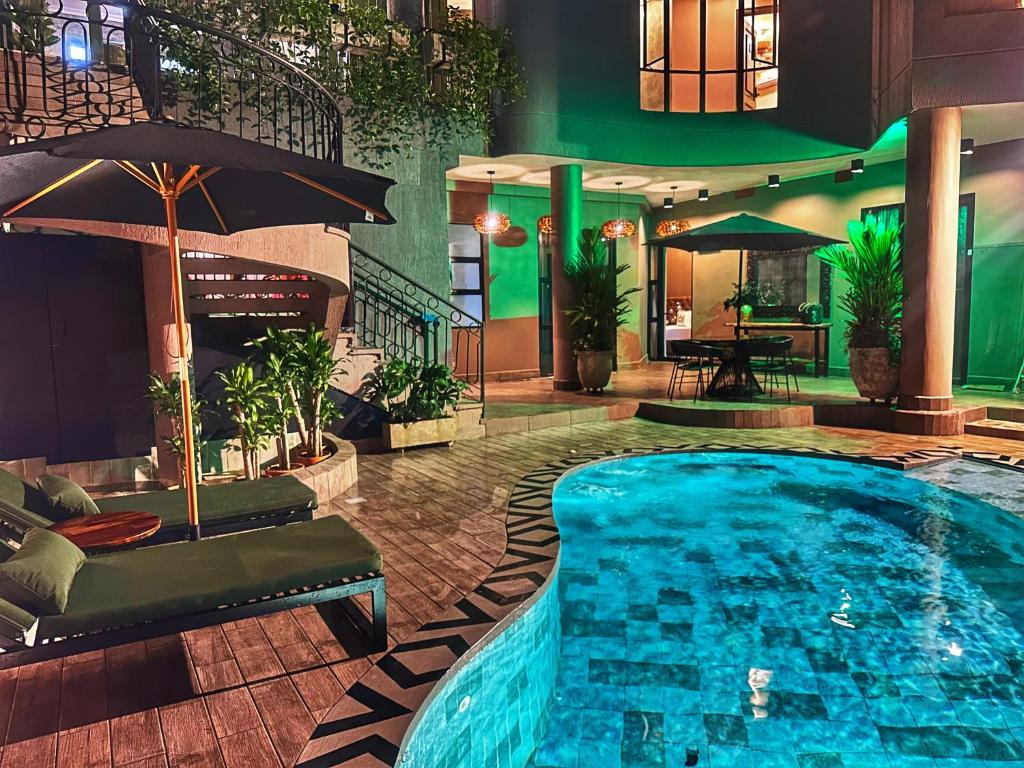 卡利Hotel Osvé Boutique Cali的一个带遮阳伞的酒店游泳池