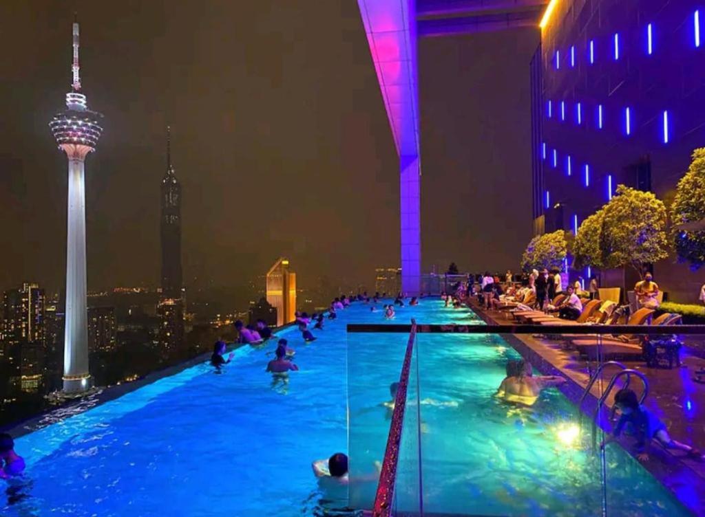 吉隆坡The Platinum Suites KLCC的一座游泳池,晚上有人在里面,有空间针