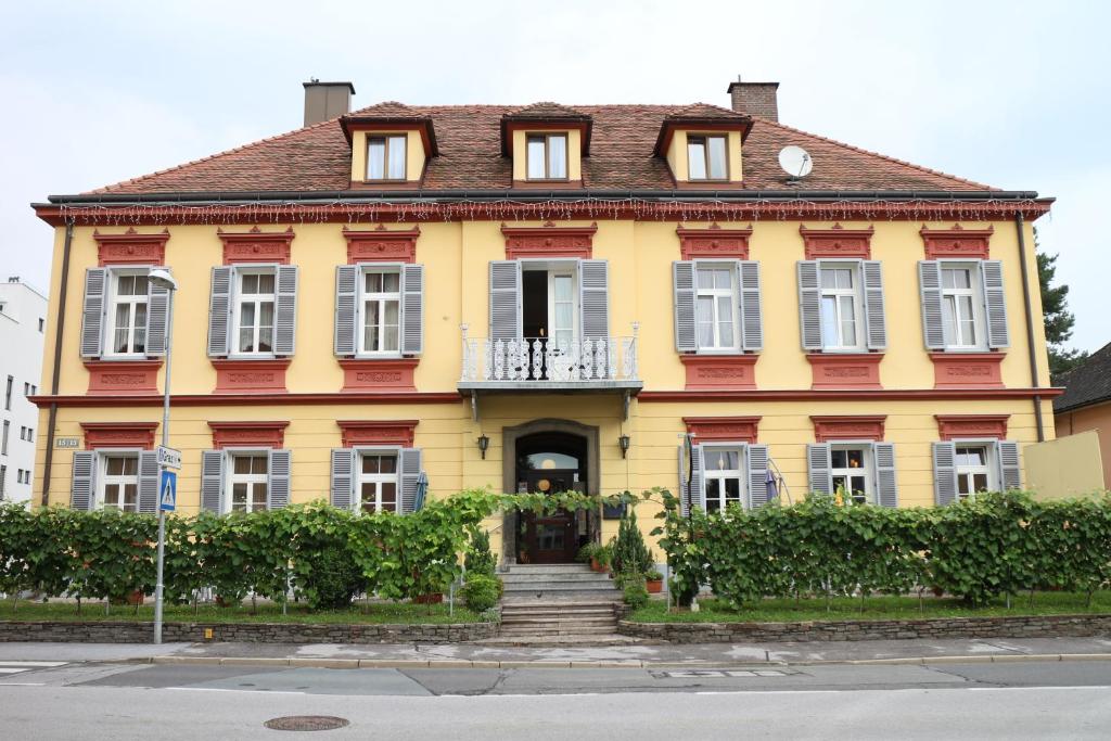 莱布尼茨Privatpension Lang的黄色和红色的房子,前面有楼梯