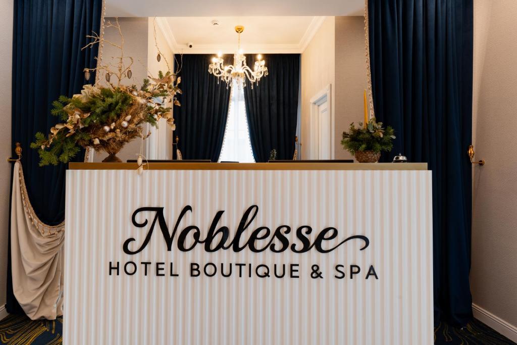 拉姆尼库沃尔恰Hotel NOBLESSE Boutique&Spa的酒店精品店和水疗中心的标志