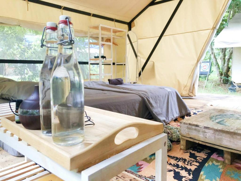 昆岛Con Dao Backpacker - LoCo Camping的帐篷内的桌子上放了两瓶玻璃瓶