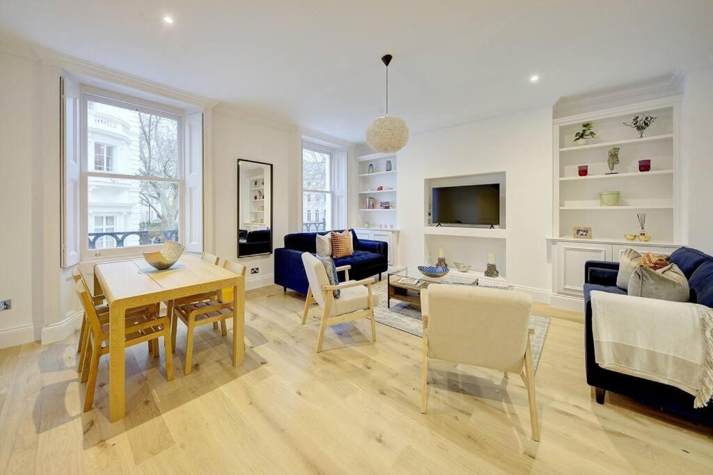 伦敦Stunning Hyde Park Apartment的一间带桌子的客厅和一间餐厅