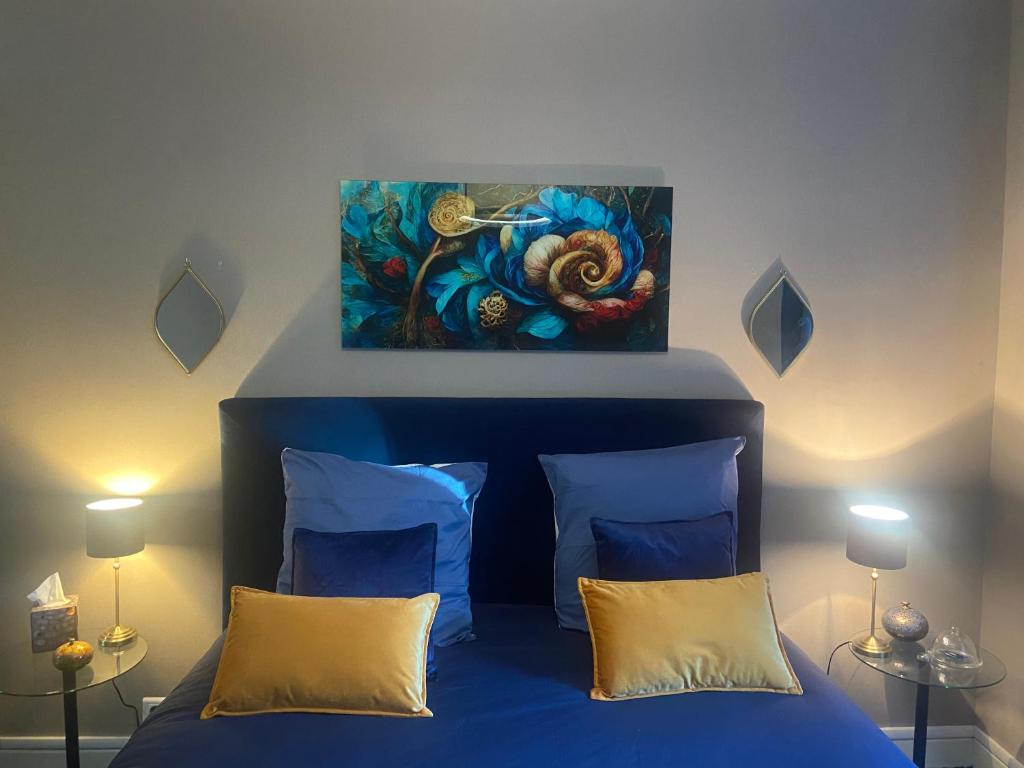 PrémilhatLe moulin de la Vernoelle的卧室配有一张蓝色的床,墙上挂着一幅画