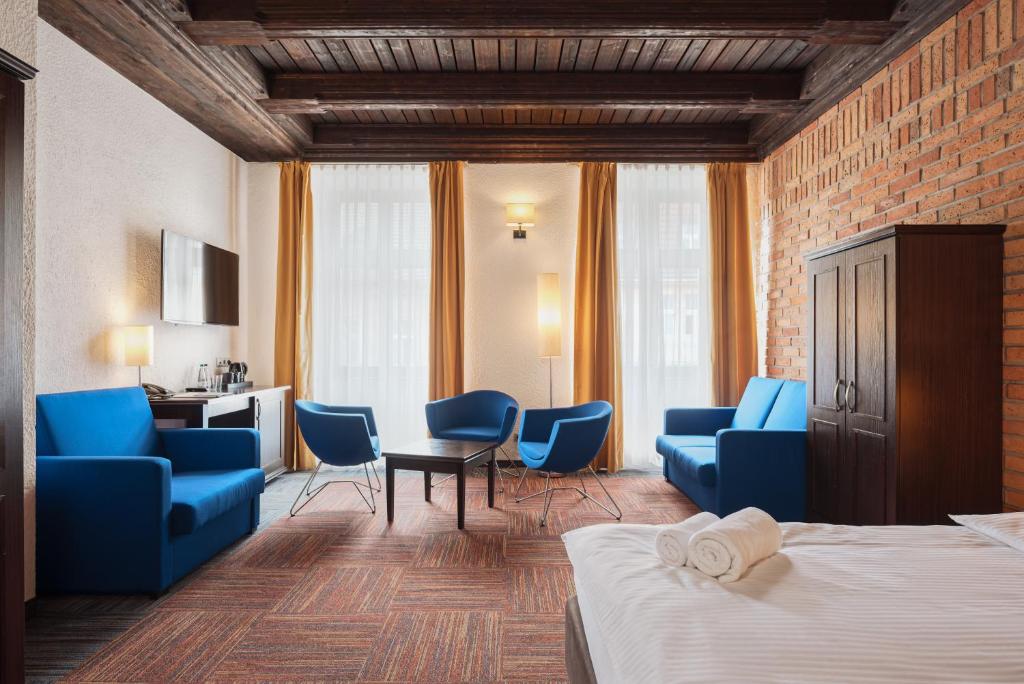 波兹南Palazzo Rosso Old Town的酒店客房带蓝色椅子和一张床
