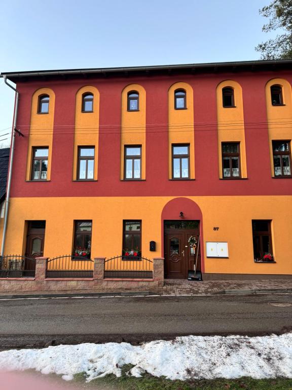 梅图耶河畔特普利采Apartmán U Splavu的街道边的红色和橙色建筑