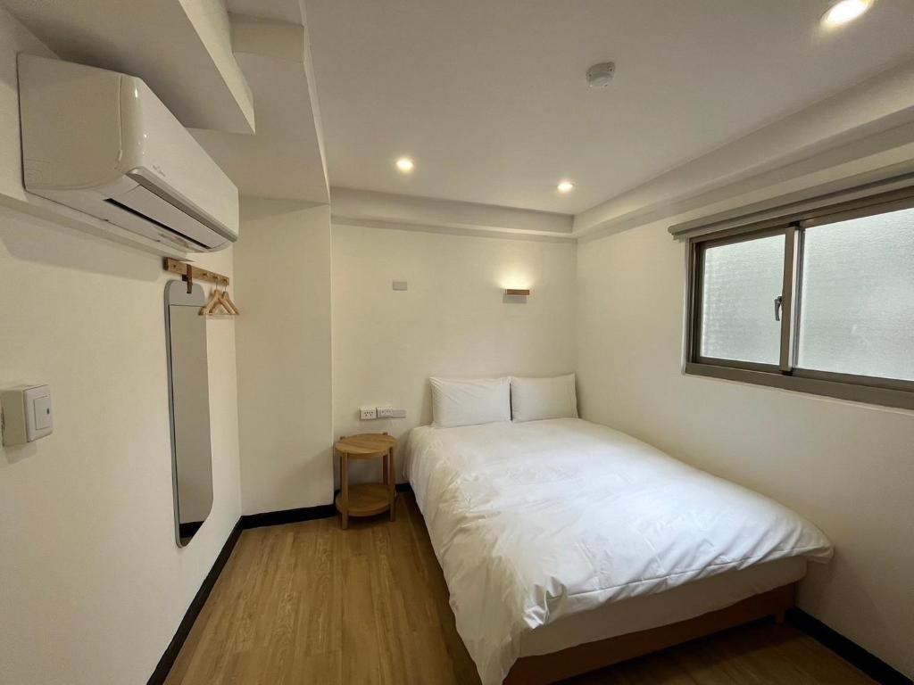 台北宏洲旅社HZ Hotel的一间小卧室,配有白色的床和窗户