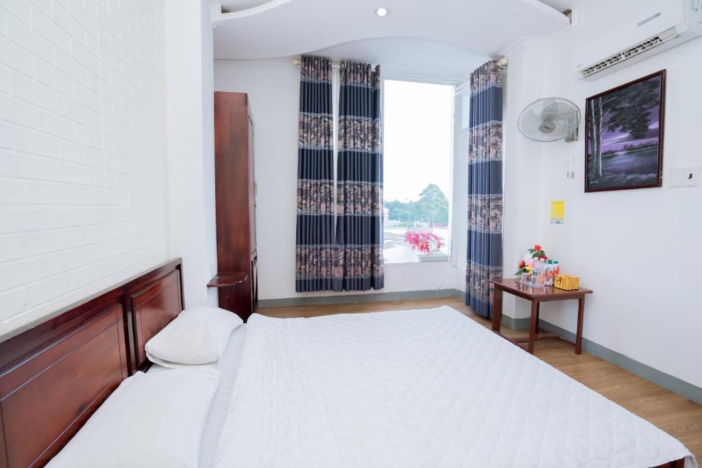 邦美蜀Triệu Vũ Hotel & Apartment的一间卧室设有一张大床和一个窗户。
